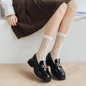 Black patent leather loafers with gold chain buckle and white lace mesh socks