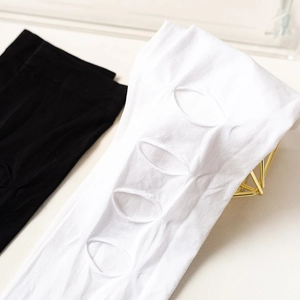 Gros plan de chaussettes hautes Lolita avec découpes ovales uniques en noir et blanc