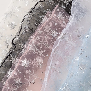 Detailed texture of mesh socks with silver snowflake patterns in various soft colors