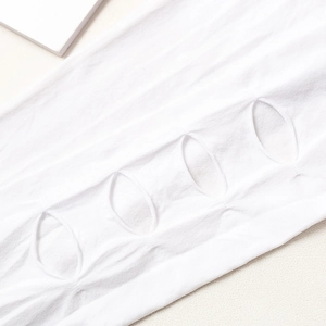 Gros plan de chaussettes hautes blanches en maille avec découpes ovales évidées
