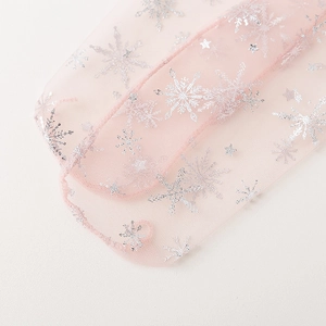 Macro shot of pink mesh fabric featuring silver snowflake and tiny star patterns