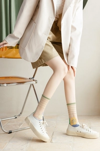 Détail de chaussettes vintage transparentes avec rayures vertes et motifs floraux