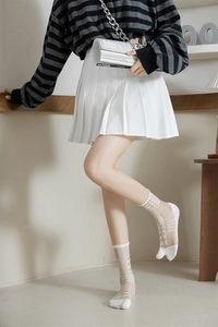 Detail view of sheer white tabi socks with geometric patterns in a Japanese lifestyle shot