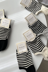 Détail de chaussettes basses rayées avec étiquettes de produit dorées élégantes
