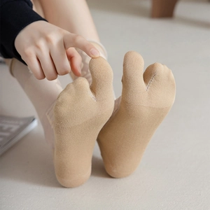 Detail of light beige tabi socks with two-toe design and breathable cotton knit texture