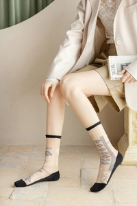 Détail de chaussettes vintage en tulle avec motifs floraux asymétriques et semelles en coton
