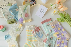 Close-up of breathable mesh knit floral socks in pastel macaron colors with daisy patterns