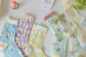 Close-up of floral mesh crew socks featuring hollow knit patterns and pastel textures