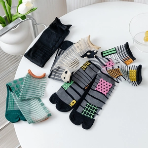 Japanese style sheer mesh two-toe socks with polka dots and stripes on white podium