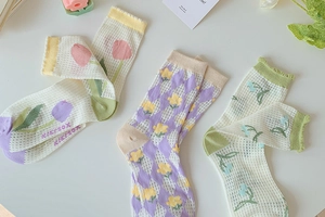 Detail view of breathable mesh socks with floral patterns and scalloped cuffs