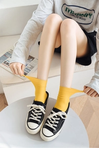 Detail shot of high-elastic yellow velvet mid-calf socks with vertical stripe texture