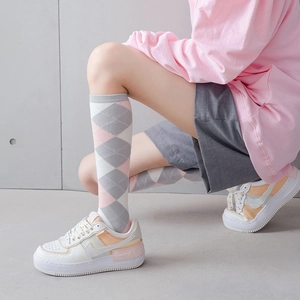 Vue détaillée de chaussettes montantes à losanges roses avec texture de tricot en coton