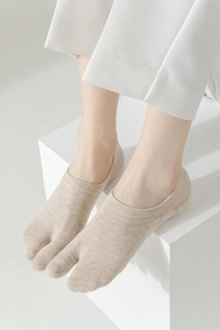 Detail showing natural beige Tabi socks with split-toe design and breathable cotton texture