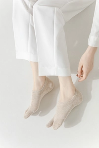 Detailed view of beige Tabi socks with two-toe design and breathable cotton fabric