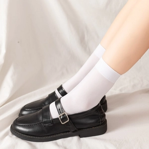 Gros plan de chaussures Mary Jane noires avec boucles et chaussettes blanches hautes