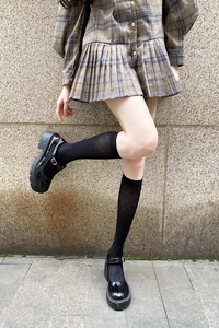 Detail of black diamond lattice calf socks paired with platform Mary Jane shoes and skirt