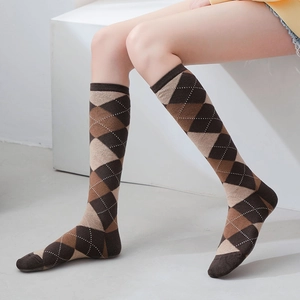 Détail de chaussettes hautes en tricot à motif argyle marron et beige avec bord côtelé