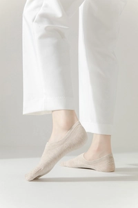 Close-up of minimalist beige two-toe split socks with breathable vertical ribbed texture