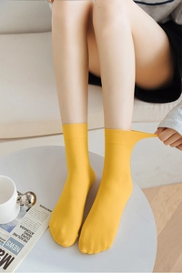 Detailed close-up of flexible yellow ribbed velvet crew socks showing high elasticity stretch