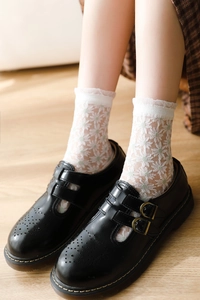 Détails de chaussettes en dentelle blanche avec broderie marguerite et bords à volants