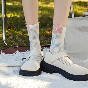 Floral mesh crew socks with off-white Mary Jane shoes shown on a picnic mat outdoors