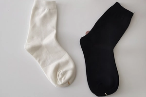Close-up of black and white cotton mid-calf socks with ribbed cuffs on white background