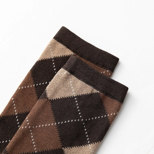 Détail macro du motif à losanges marron et revers côtelé sur des chaussettes en maille