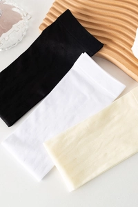 Detail of white argyle velvet calf socks with ribbed cuffs and textured knit pattern