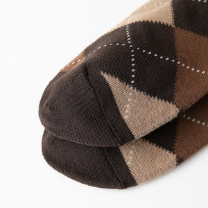 Détail du tricot serré et de la pointe sans couture de ces chaussettes mi-mollet à losanges