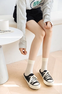 Detailed texture of white velvet mid-calf socks with vertical stripes and ribbed cuffs