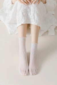 Detail of white lace mesh socks with delicate floral patterns and ruffled cuff design