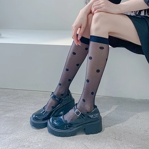 Polka dot mesh knee-high socks paired with black platform Mary Jane shoes