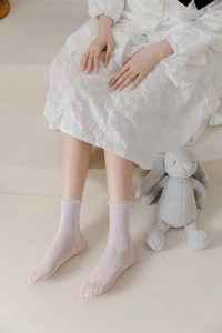 Close-up of white lace mesh socks featuring delicate ruffle cuffs and geometric hollow patterns