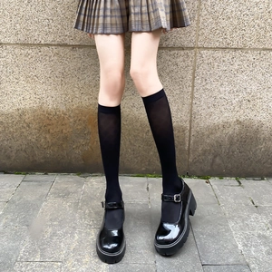 Black platform Mary Jane shoes paired with white diamond pattern knee-high calf socks