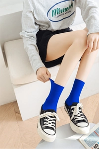 Close-up of royal blue ribbed velvet socks showing elastic stretch and vertical stripe texture