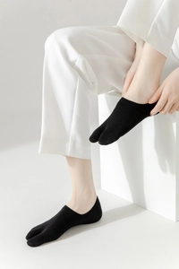 Detailed view of black two-toe non-slip cotton socks with low cut design on feet