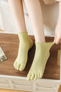 Detail of grass green five-finger mesh socks with hollow-out lace trim and toe separation