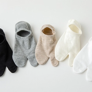 Close-up of assorted two-toe tabi socks in neutral colors with soft cotton knit texture