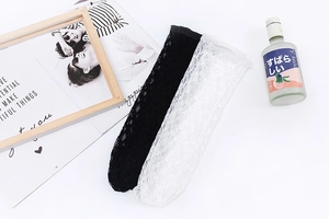 Détails des motifs en dentelle ajourée sur chaussettes Lolita blanches et noires