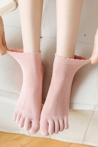 Detail of pink hollow-out five-finger socks with breathable mesh and ruffled lace cuffs