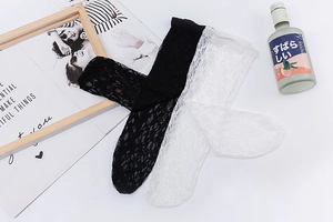 Détail de la bordure en dentelle et maille ajourée sur chaussettes Lolita blanches et noires