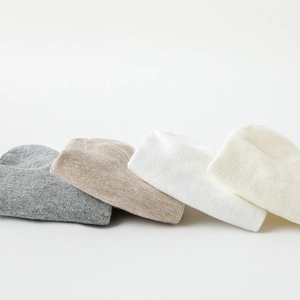 Detailed view of four pairs of knitted low-cut socks in white, gray, and beige tones