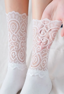 Gros plan de chaussettes en dentelle blanche aux motifs floraux de style Lolita