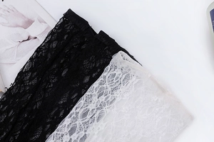 Détail de manches en dentelle florale avec poignets élastiques en noir et blanc