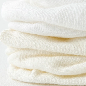Close-up of white knit fabric texture showing high-quality soft breathable weave detail