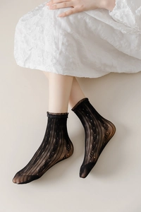 Detailed view of black lace socks featuring vintage diamond patterns and ruffled edges