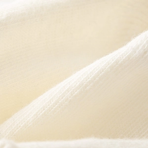 Macro detail of white breathable knitted fabric showing soft texture and high-quality fibers