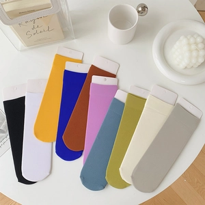 Close-up of ten pairs of colorful vertical striped velvet crew socks in fan-shaped layout