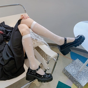 Japanese style Lolita white polka dot knee high socks paired with black platform Mary Janes