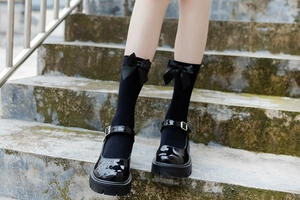 Detail of JK uniform black mid-calf socks with satin bow and platform Mary Jane shoes